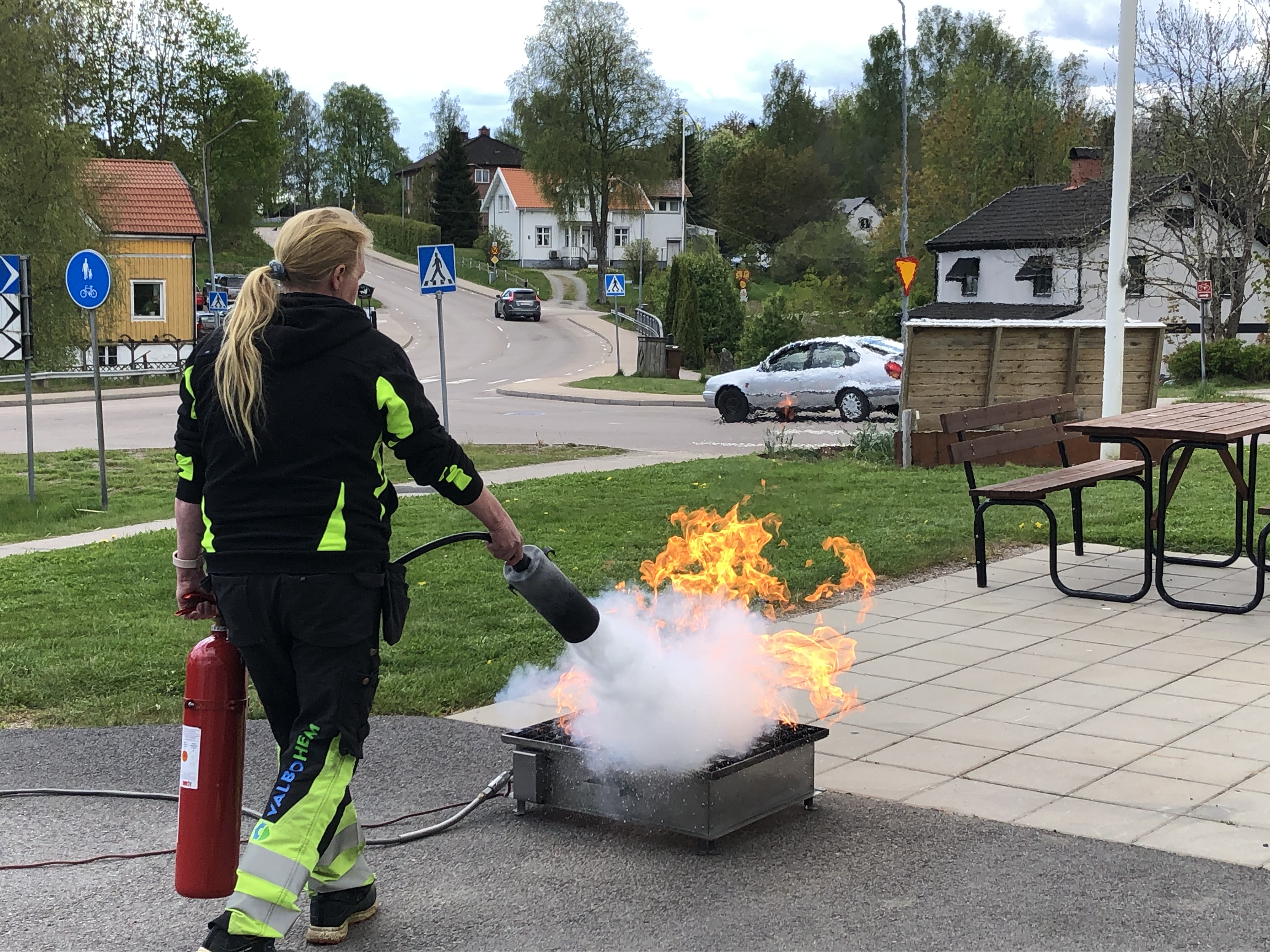 En kvinna med brandsläckare släcker en eld