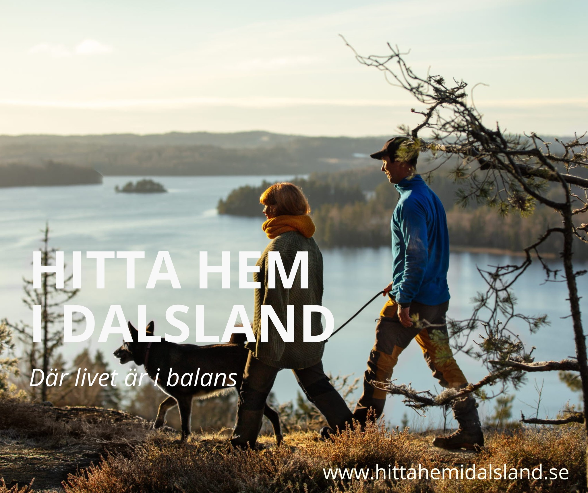 Två personer vandrar med en hund