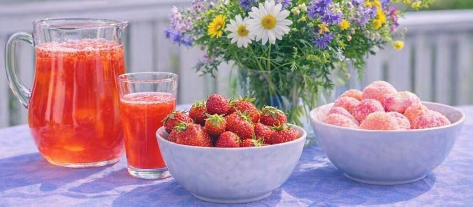 Ett bord med saft, jordgubbar och glass