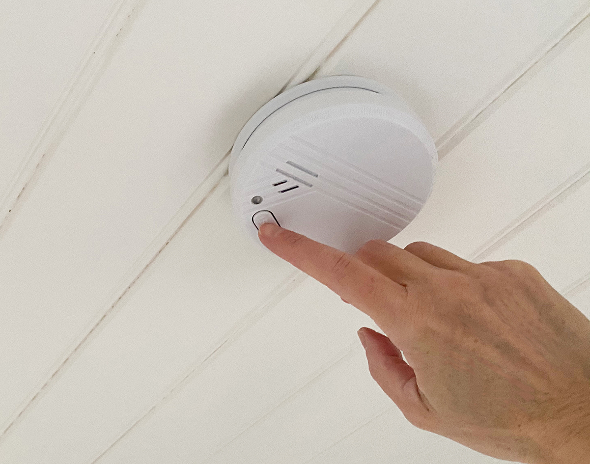 En hand testar brandvarnaren